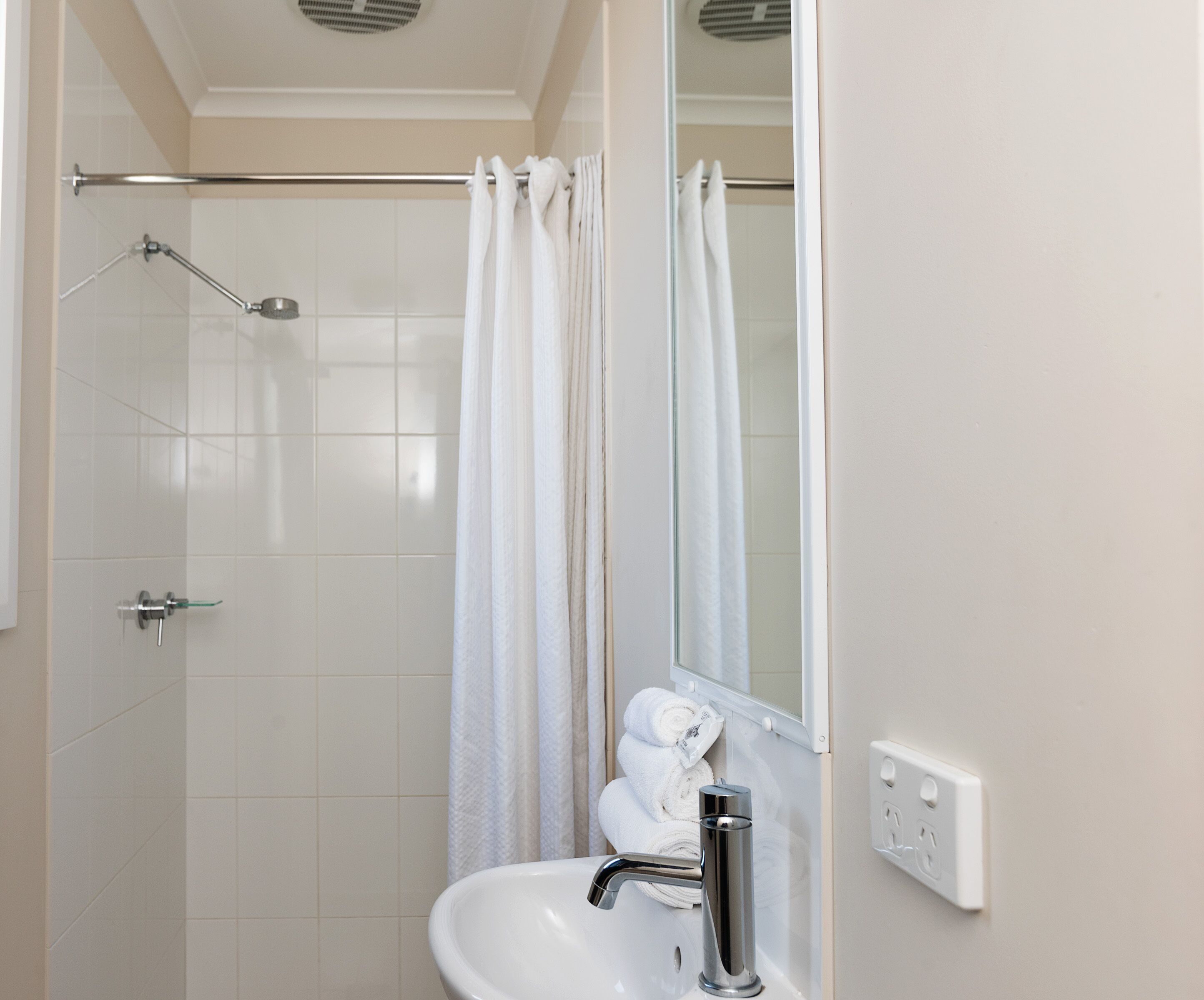 Un bany amb dutxa, un lavabo i un mirall.