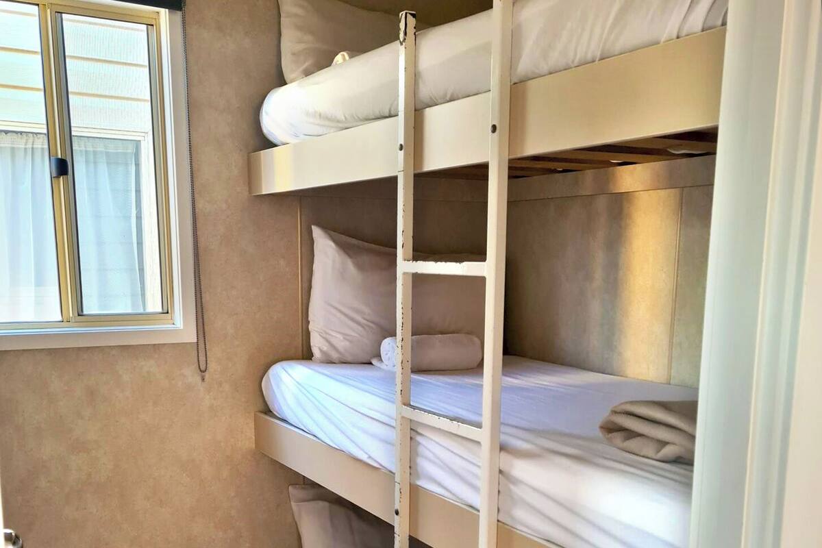 A bunk bed with two levels, each with pillows and blankets.