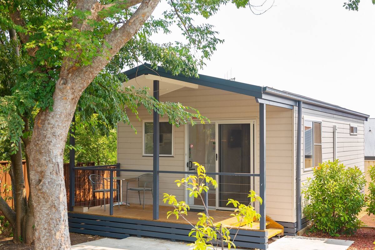 A single-story house with a covered porch, a sliding glass door, and a small deck.