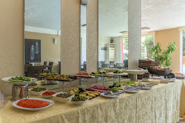 Una mesa de buffet con diversos alimentos y utensilios.
