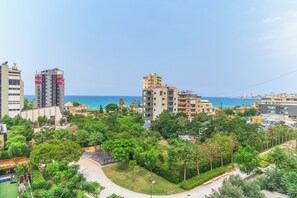 Zona residencial costera con edificios altos, abundante vegetación y una vista despejada del mar.