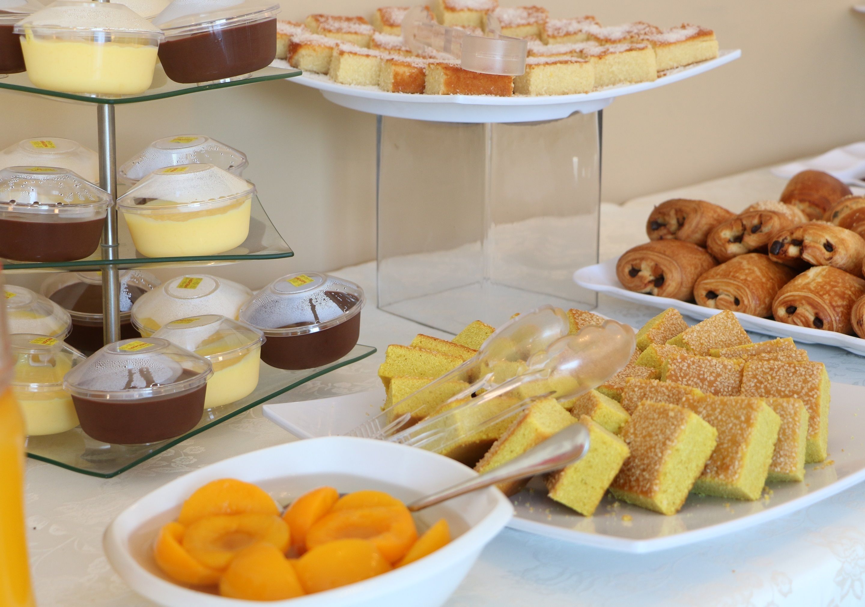 Un buffet proposant une variété de desserts, notamment des gâteaux, des pâtisseries et des fruits.