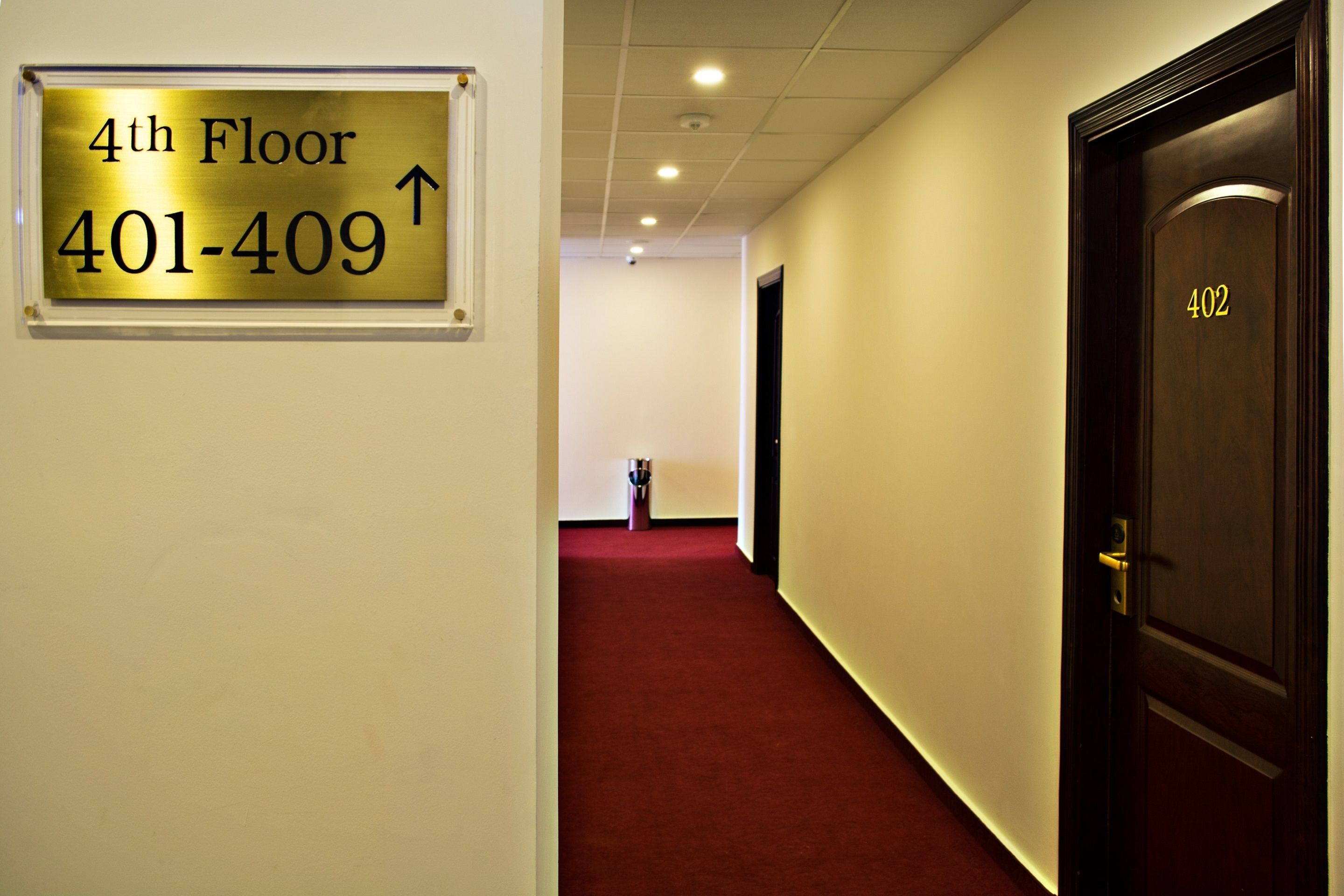 A hallway with a sign indicating the 4th floor and a phone number.