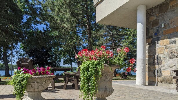 Area esterna con fioriere in pietra e vista sul lago.