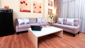 A modern living room with two sofas, a coffee table, and a flat-screen TV.