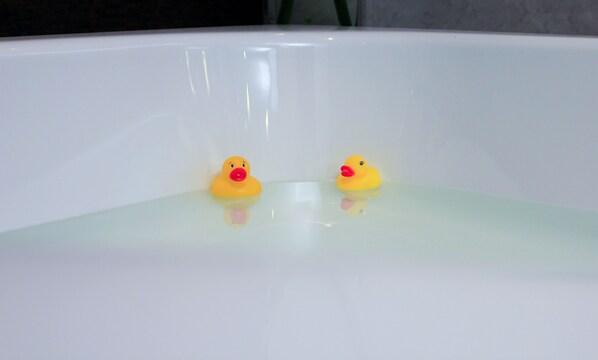 Una bañera con dos patitos de goma.