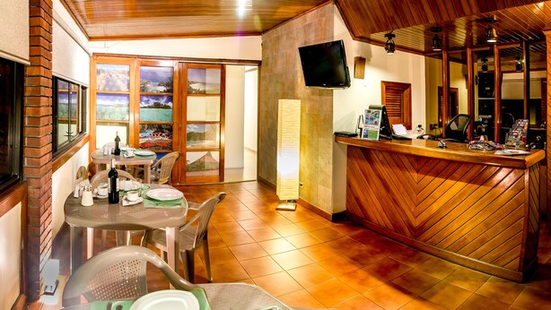 A restaurant with a wooden interior, a bar area, and a television mounted on the wall. - Pacific Dreams (Panama City)