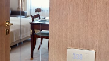 Une porte de chambre d’hôtel avec une plaque portant le numéro 339, une table de chevet, une chaise et un lit avec une tête de lit.