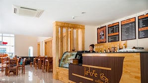 A coffee shop interior with a wooden counter, menu boards, and seating area. - J'adore Lodge (Phnom Penh)