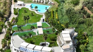 An aerial view of a resort with a swimming pool, multiple guest rooms, and a landscaped garden. - Infinity Resort Tropea (Parghelia)