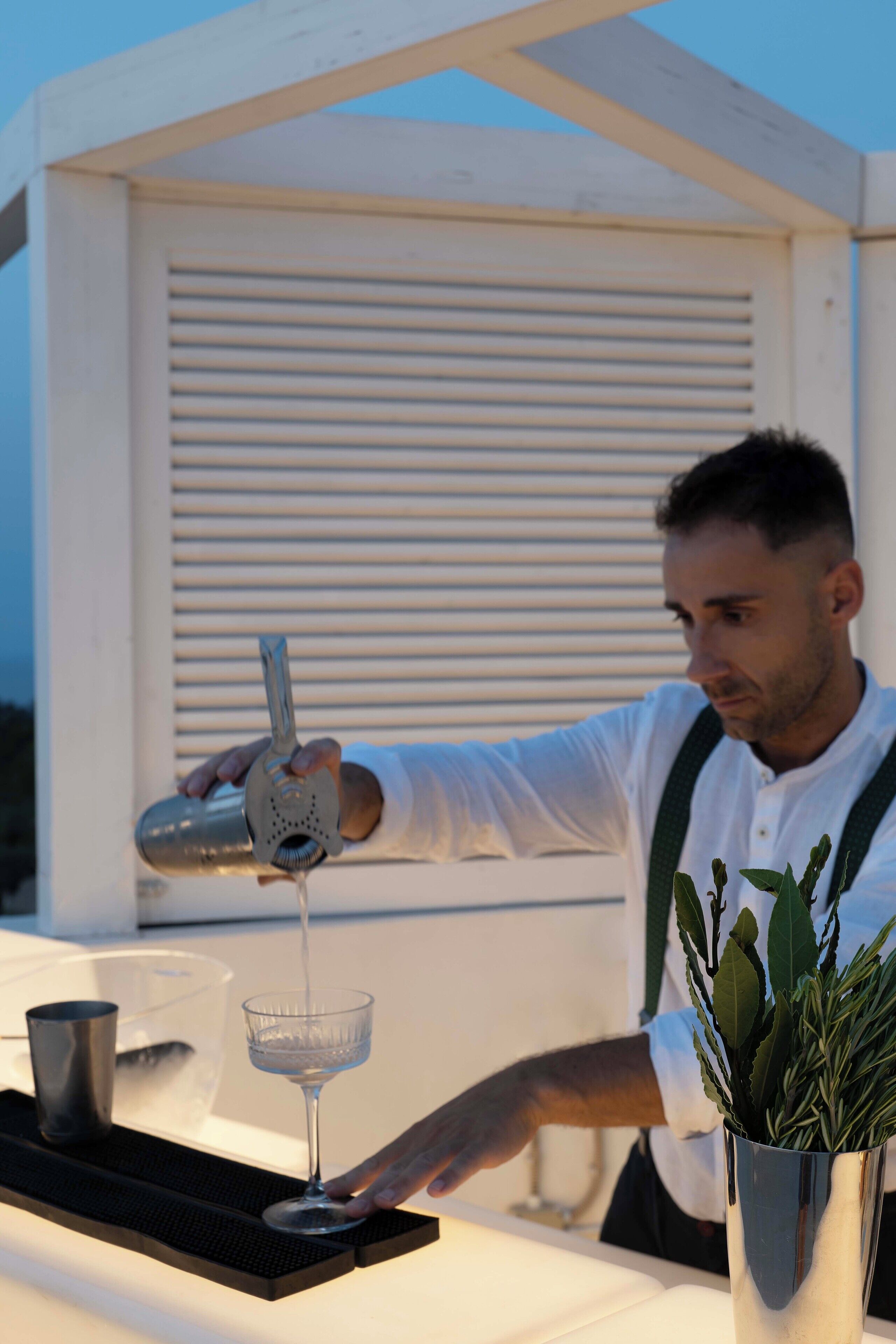 Un barman sirviendo una bebida en un vaso.