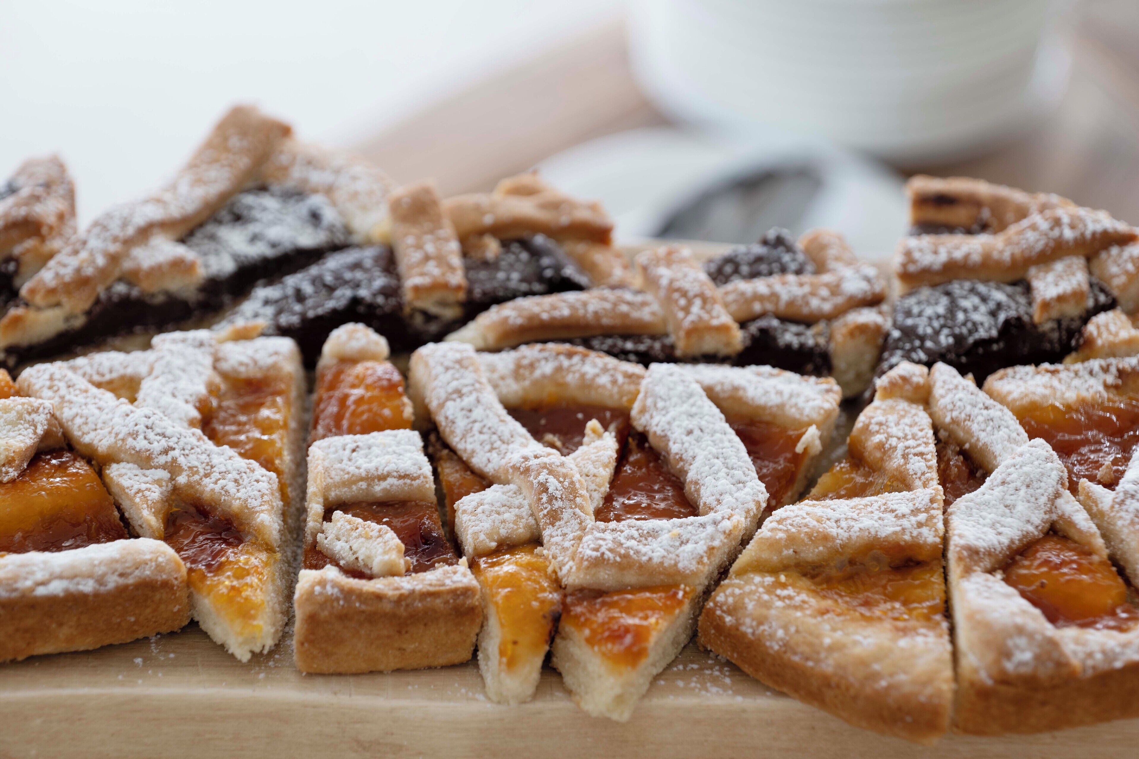 A close-up of a dessert with a lattice crust and powdered sugar.