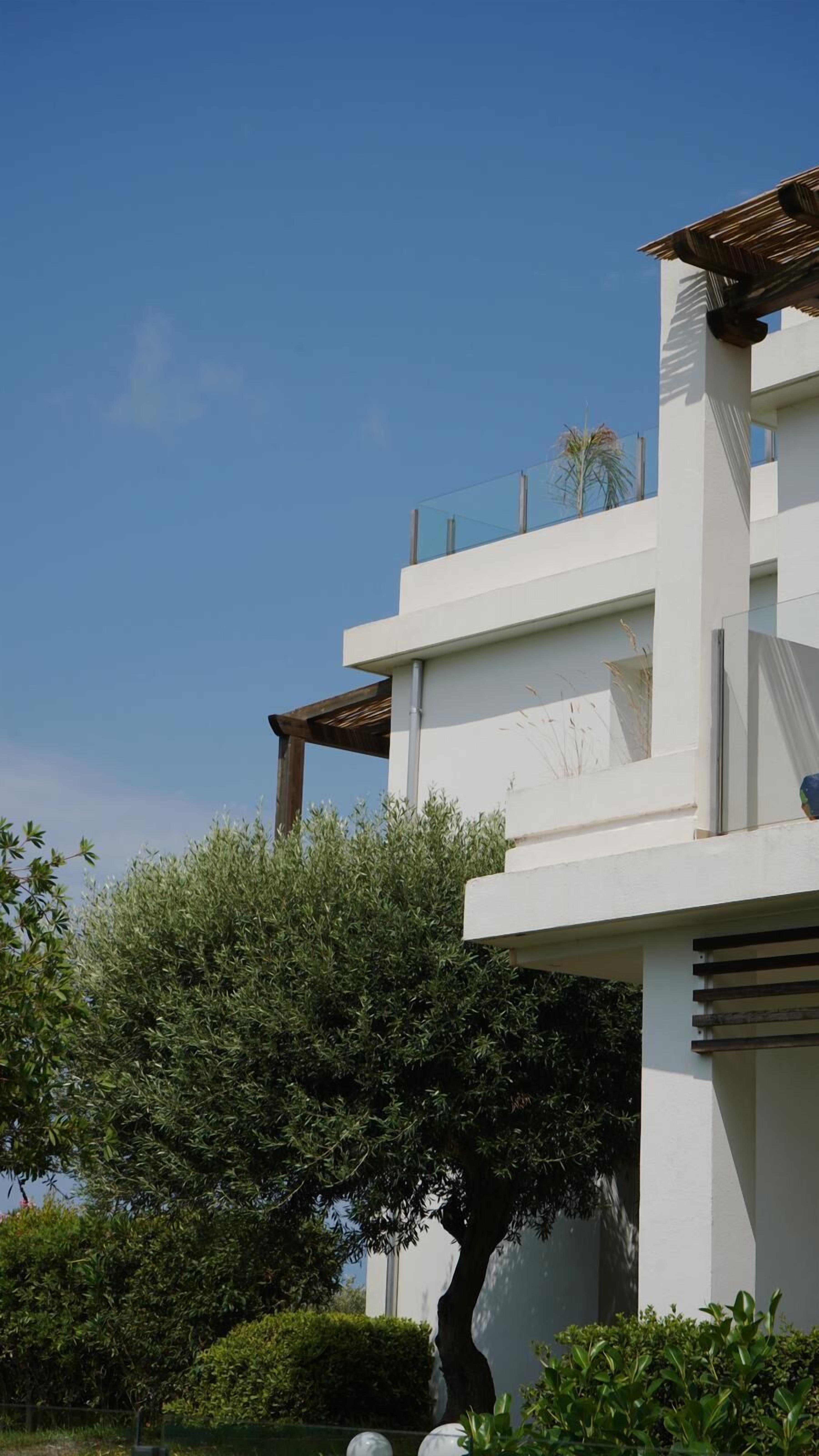 Een modern gebouw met een plat dak, grote ramen en een balkon.