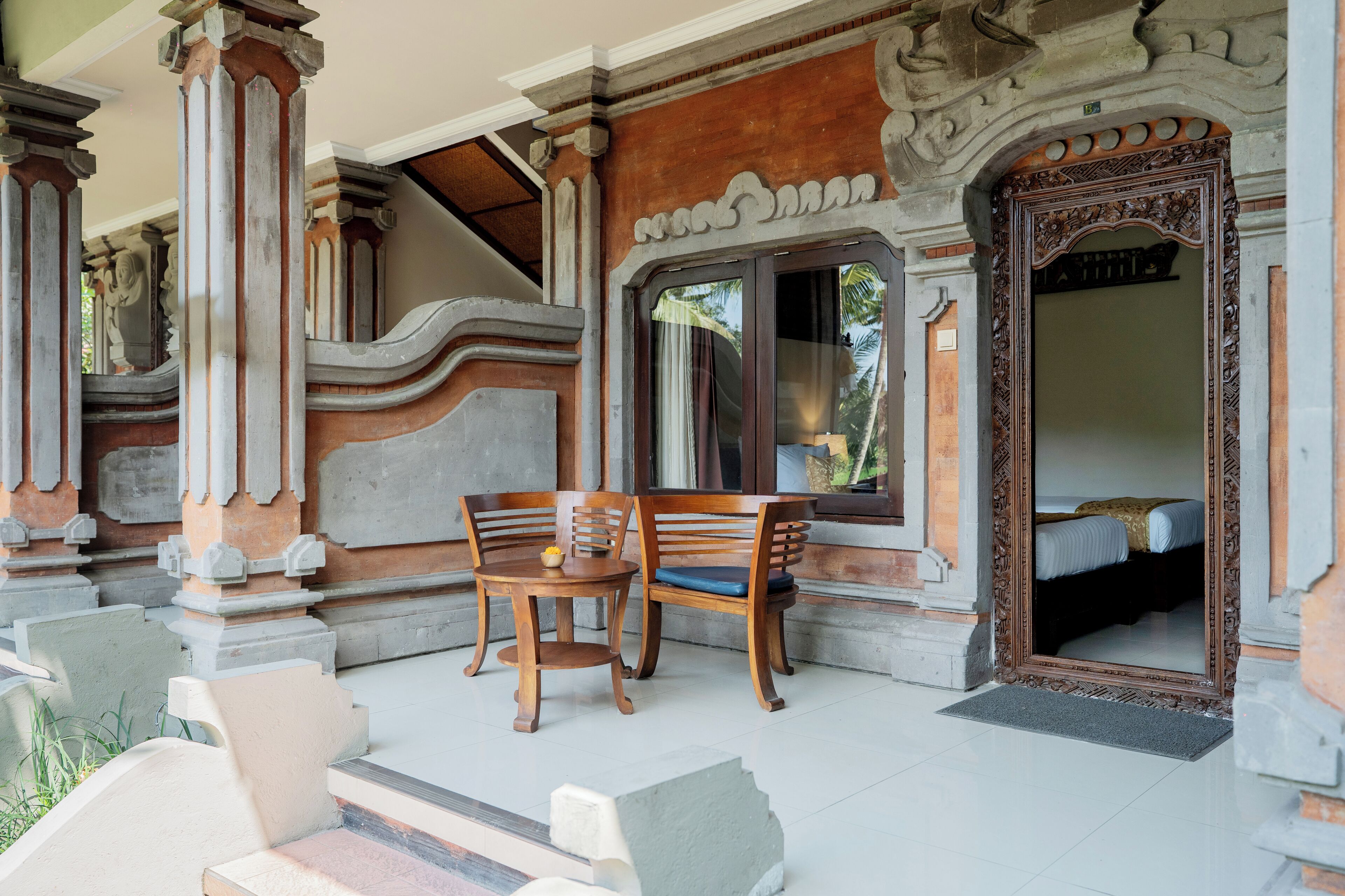 Een kamer met een bed, een houten stoel en een tafel.