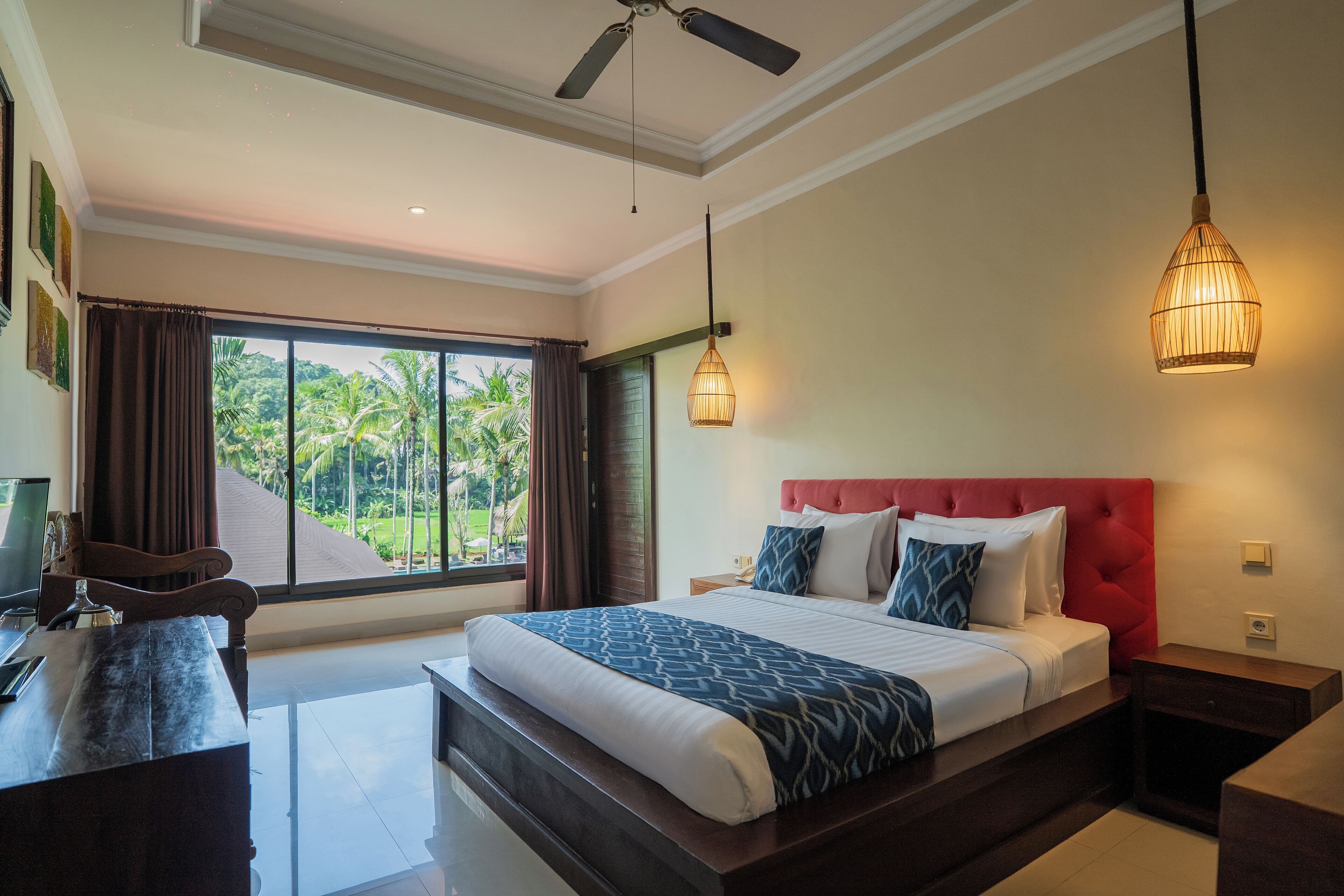 Un dormitorio amplio con una cama grande, un escritorio y vistas al exterior.