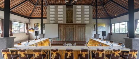 A conference room with a long table, chairs, and a decorative wall panel.