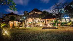 A traditional building with a central pavilion, surrounded by well-maintained lawns and trees. - Kuta Puri Bungalows, Villas and Resort (Kuta)