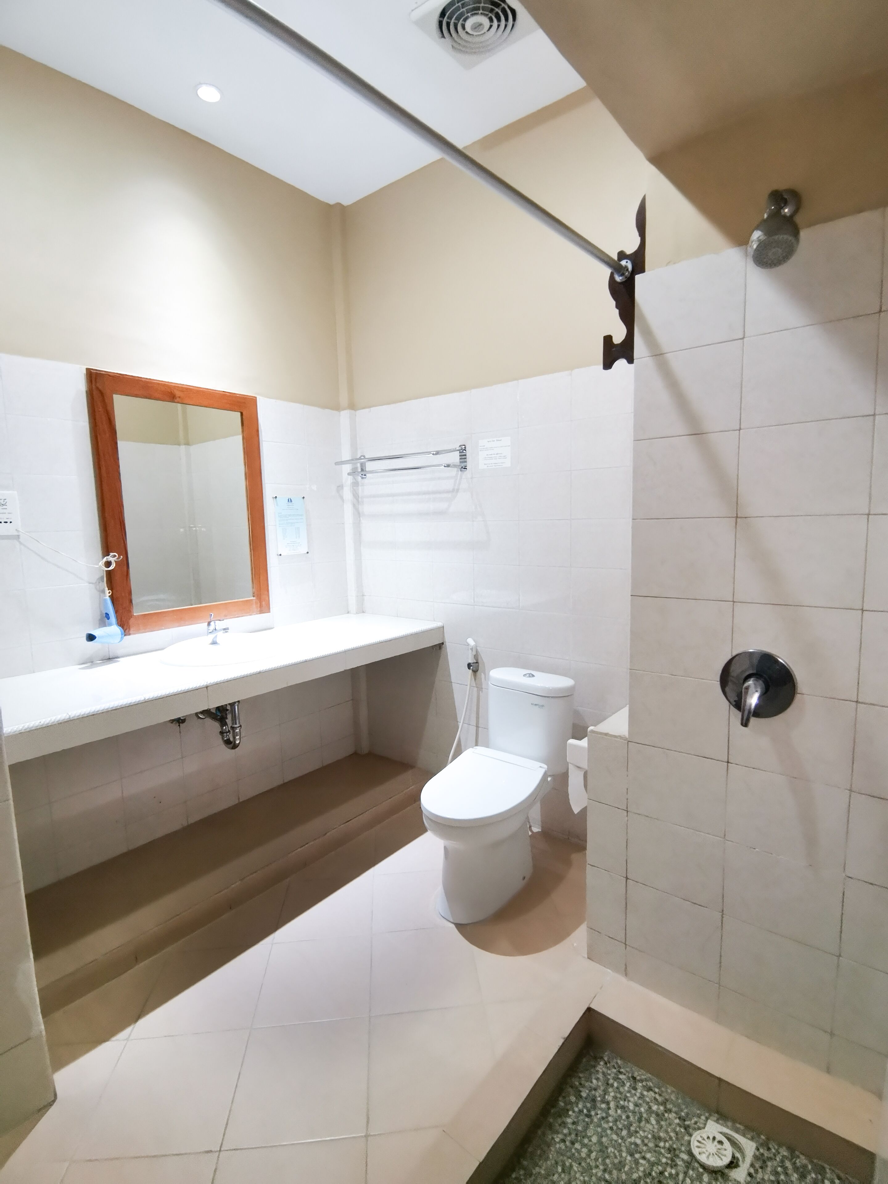 A bathroom with a white sink, mirror, toilet, and shower.