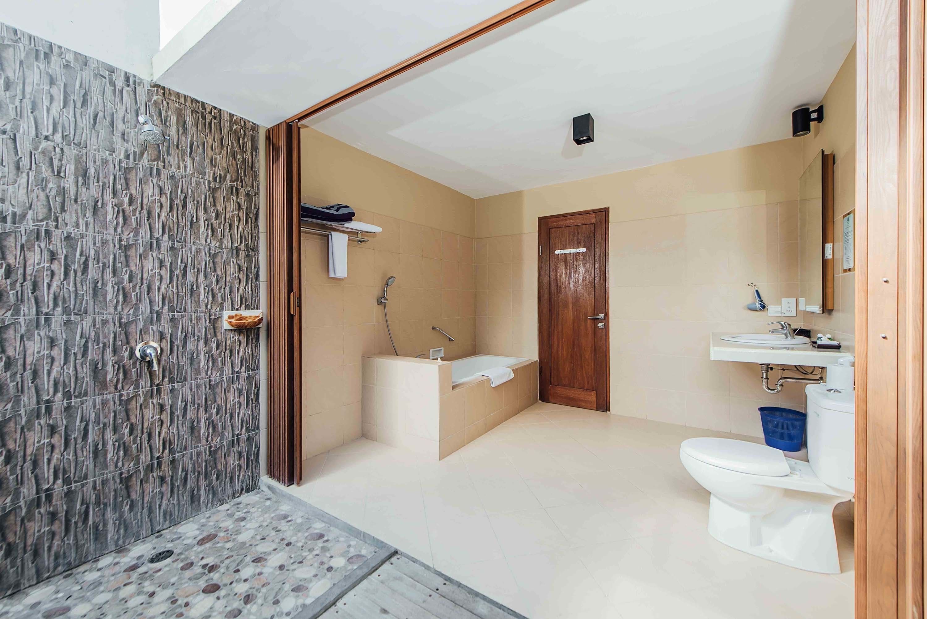 A bathroom with a shower, bathtub, toilet, and sink.