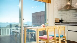 Uma cozinha moderna com uma janela grande, cadeiras de madeira e vista para o exterior.