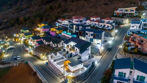 Uma área residencial com casas modernas, uma estrada sinuosa e um estacionamento.
