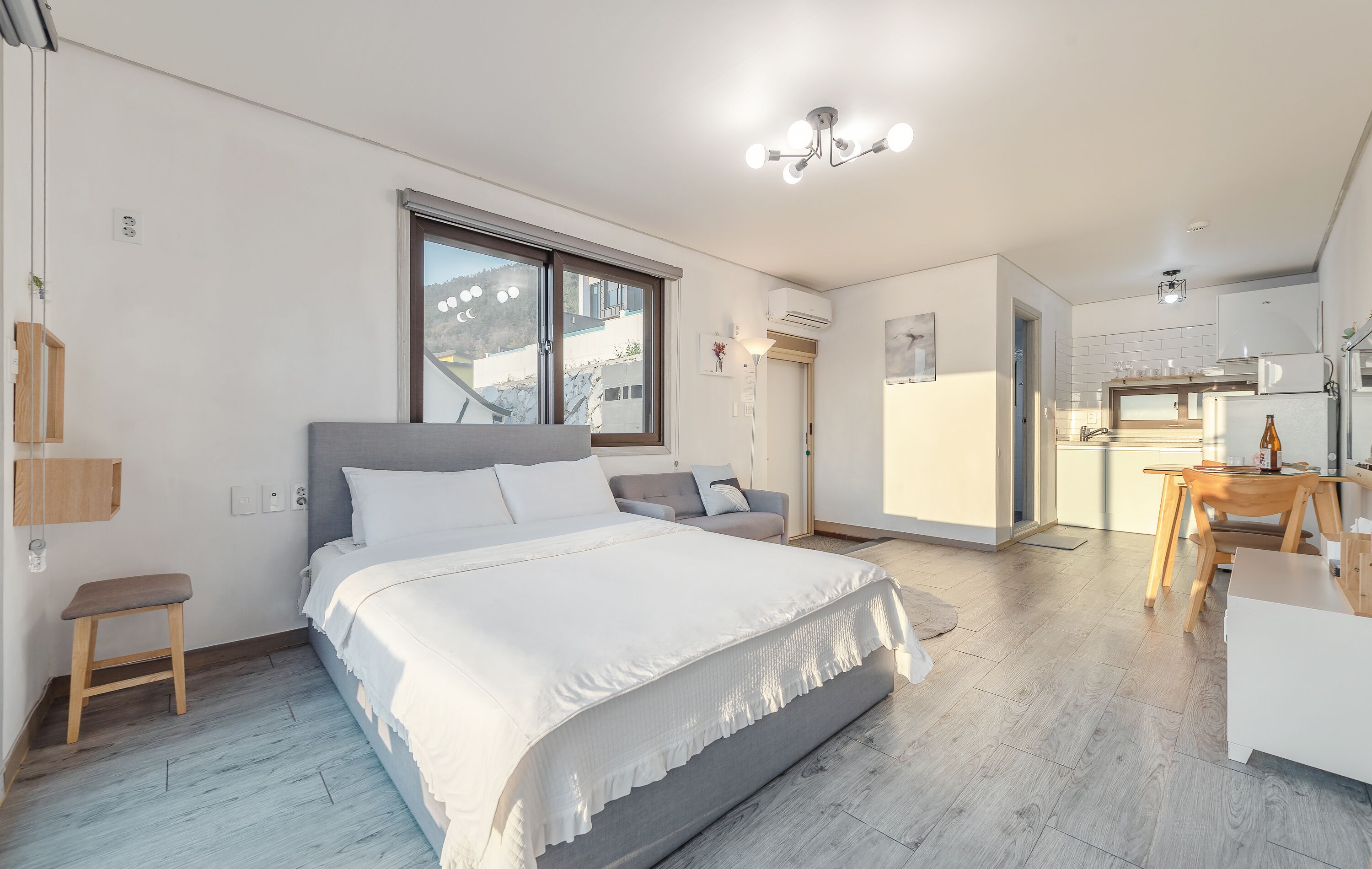Une chambre moderne avec un grand lit, un bureau et un coin repas.