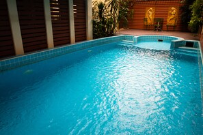 Una piscina al aire libre, tumbonas