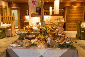 Un bufé con diversos postres y frutas.