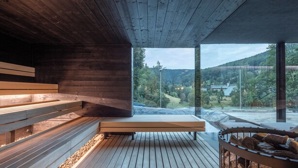 A wooden interior with benches and a view of a forested landscape. - Pytloun Wellness Hotel Harrachov (Harrachov)