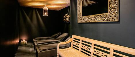 A modern spa room with a wooden bench, a wall-mounted mirror with intricate carvings, and a ceiling with wooden slats.
