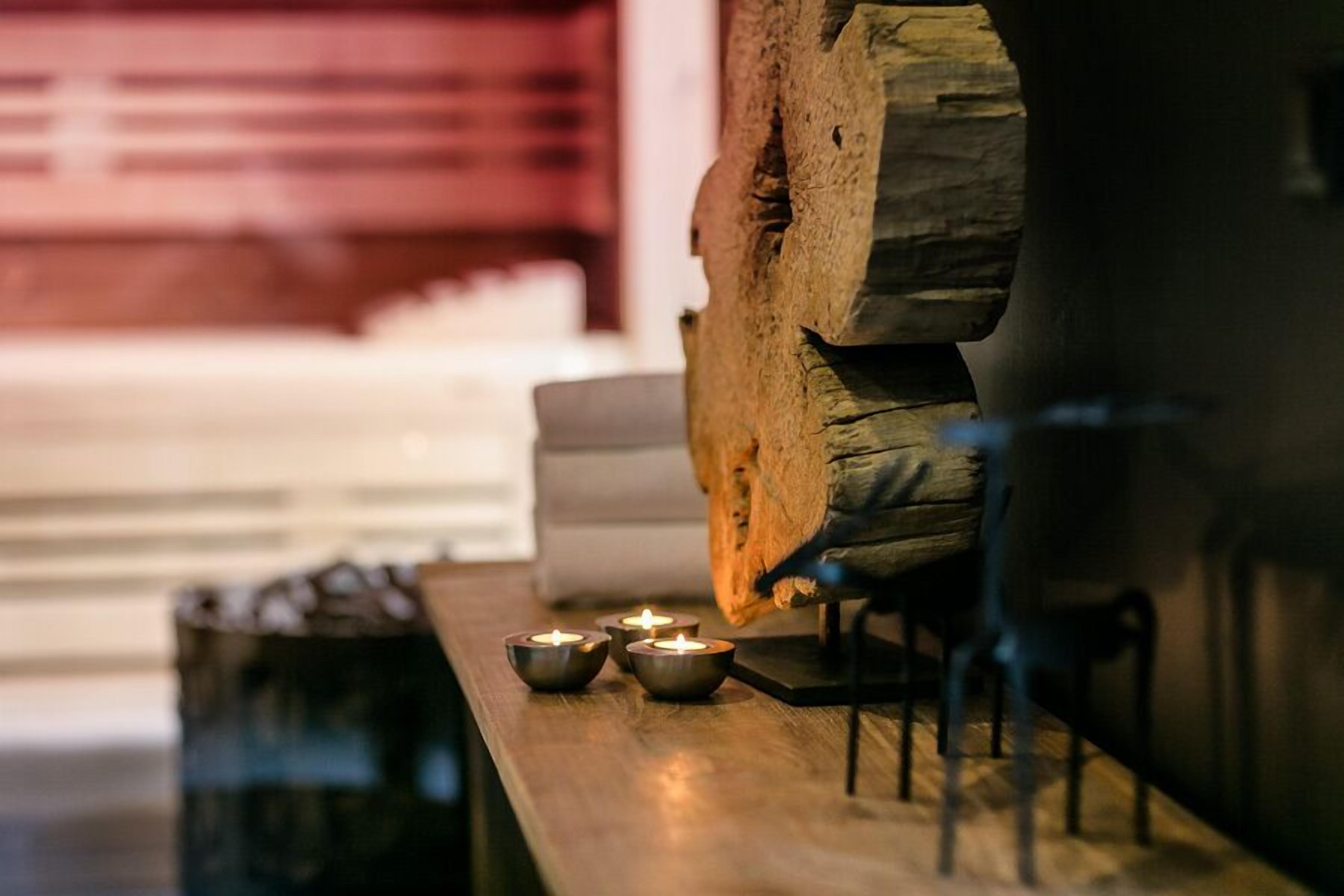 Una mesa de madera con velas y un tronco rústico.