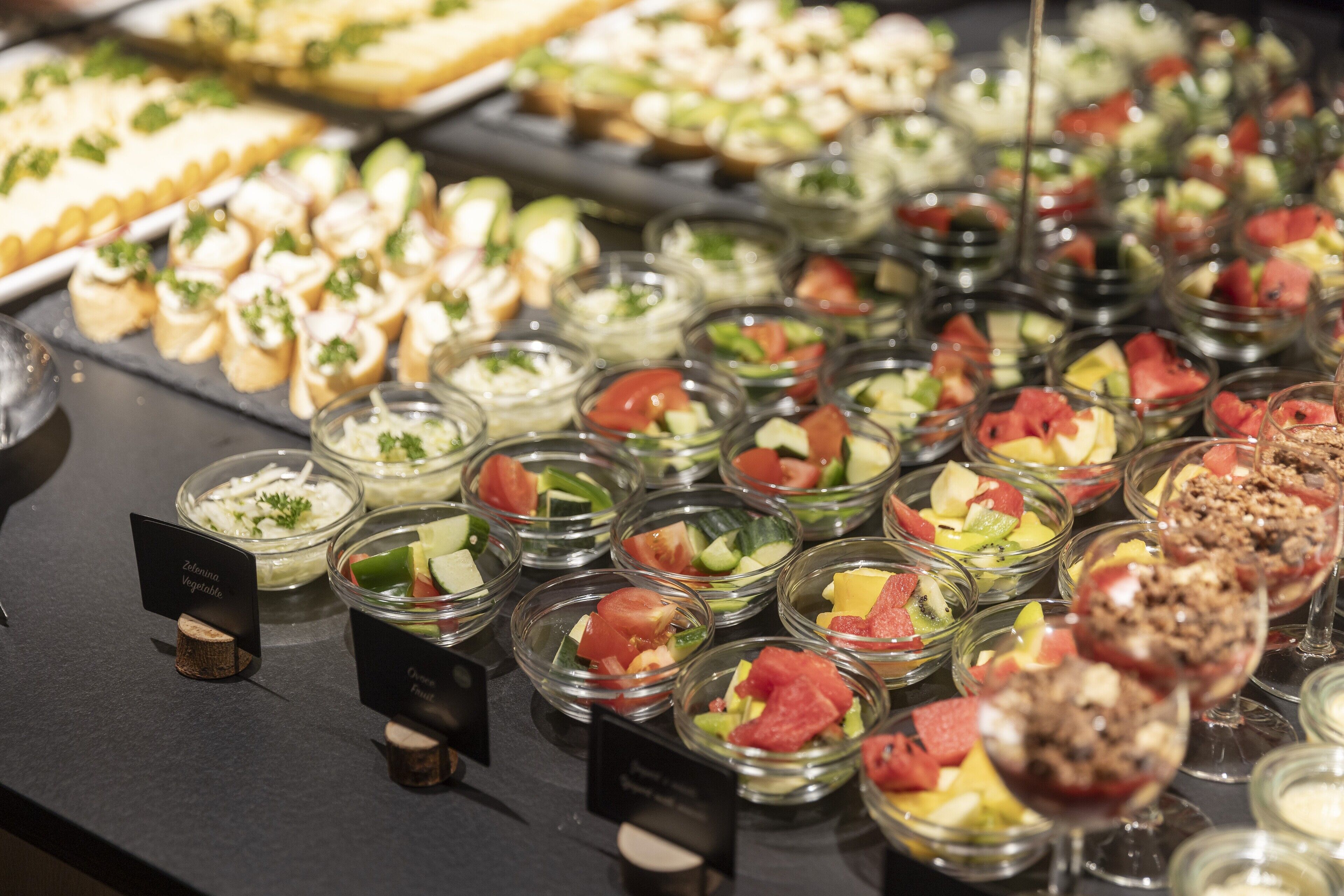 En buffet med et bredt udvalg af mad, herunder salater, frugt og desserter.