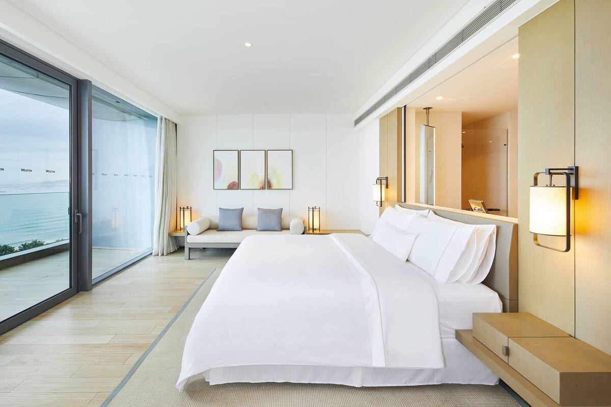 Une chambre d’hôtel moderne avec un grand lit, un canapé et une vue sur la mer.