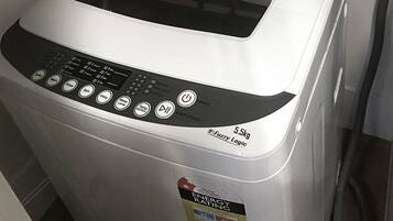 Una lavadora compacta y moderna con un panel de control que tiene varios botones para distintas funciones.