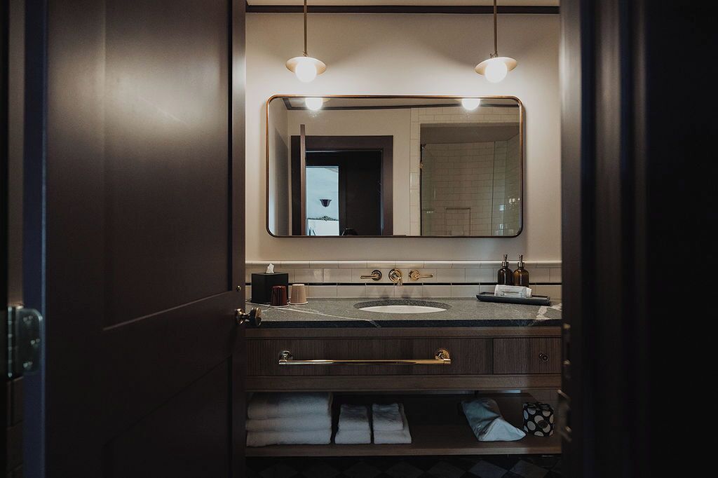 Une salle de bain moderne avec un meuble-lavabo en bois foncé, un grand miroir et un lavabo.