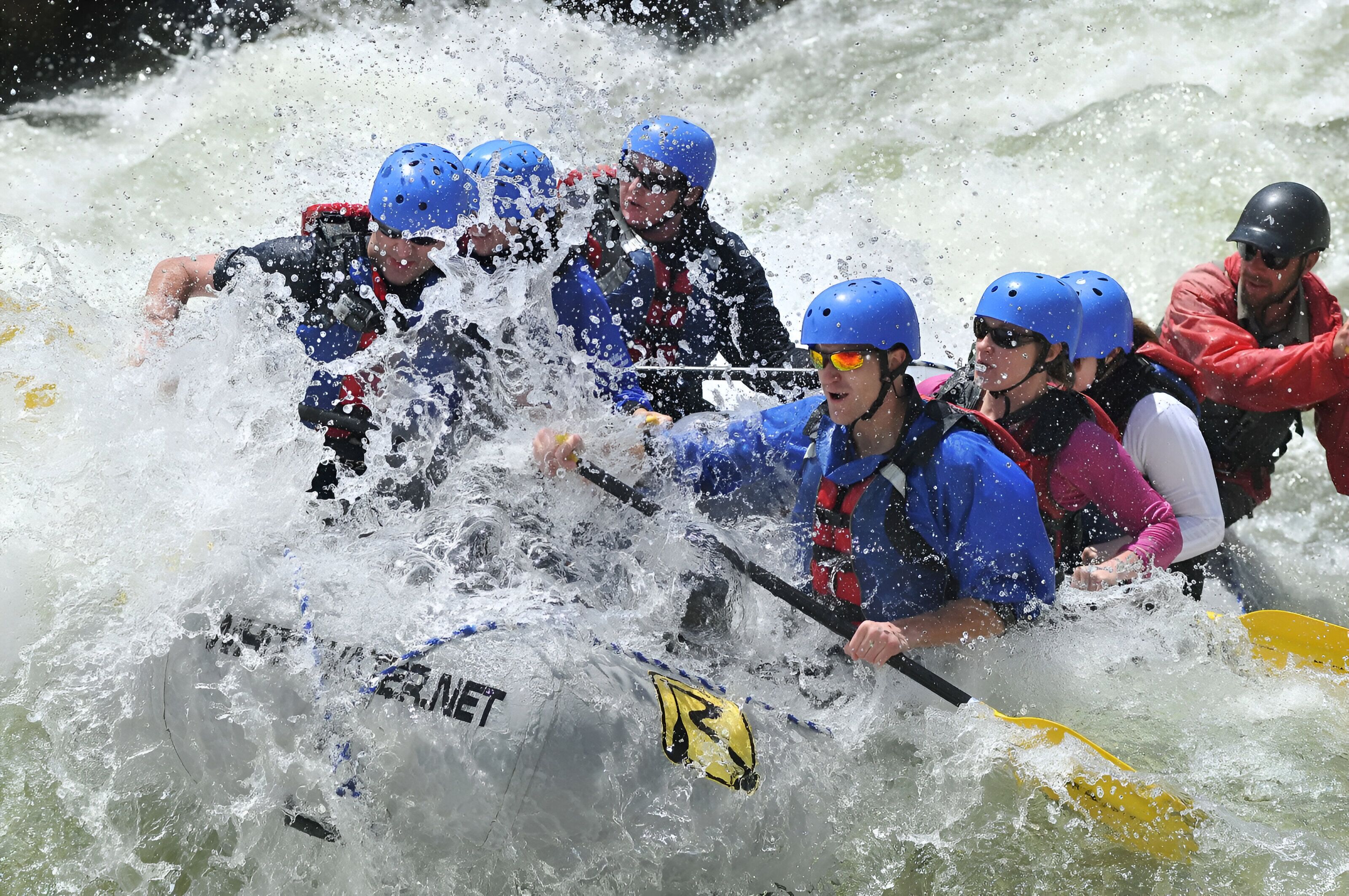 A group of people in a raft navigating through a river.