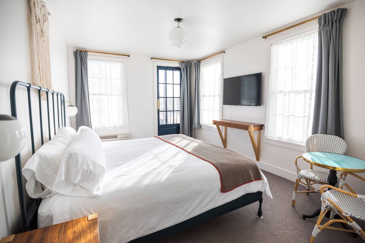 Een hotelkamer met een bed, bureau, stoel en televisie.