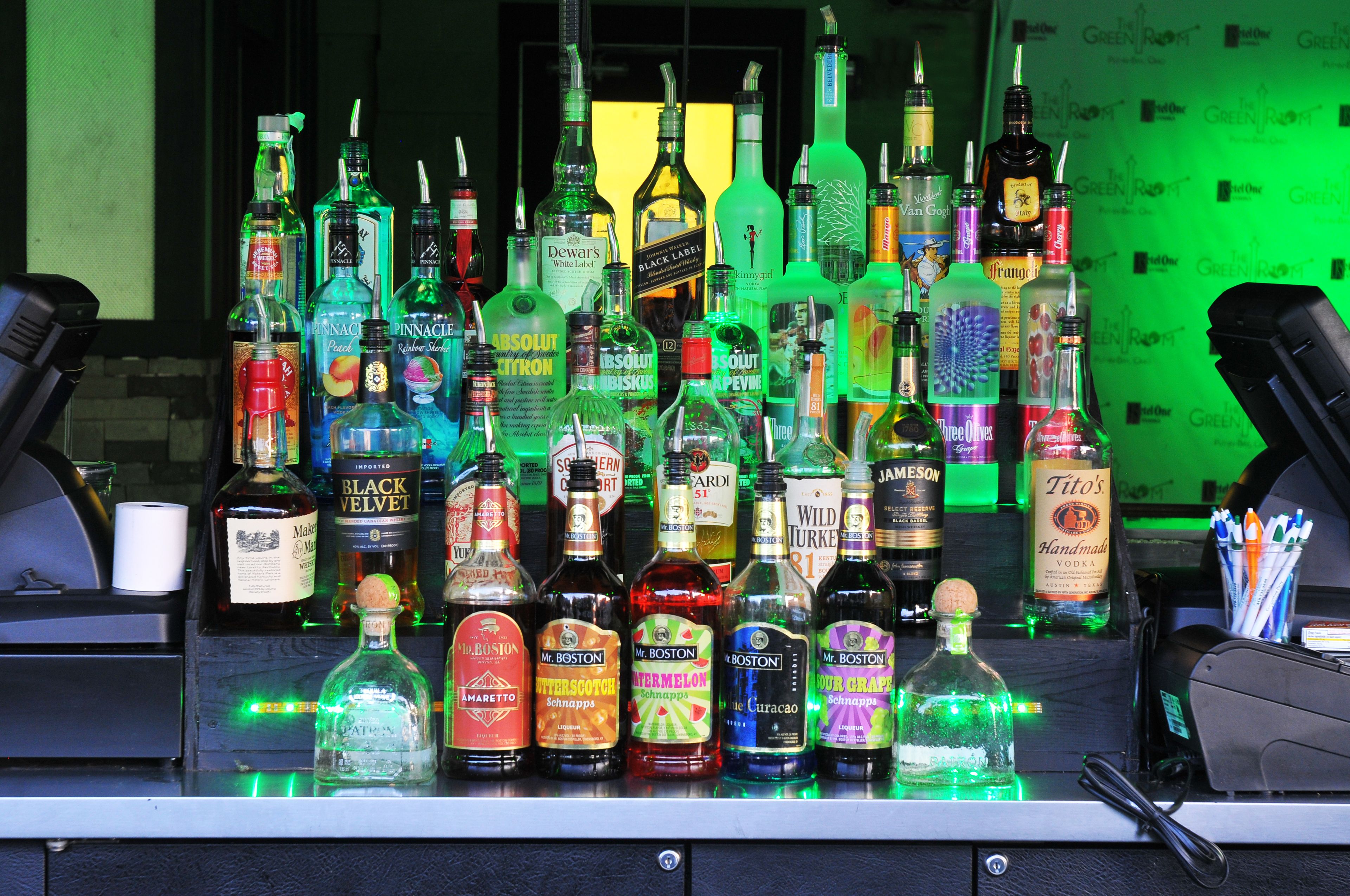 A bar with various liquor bottles and a cash register.