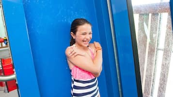 Una persona apoyada en una pared azul.