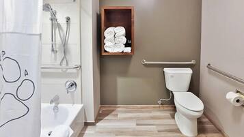 Une salle de bain avec une douche, des toilettes et une étagère avec des serviettes.