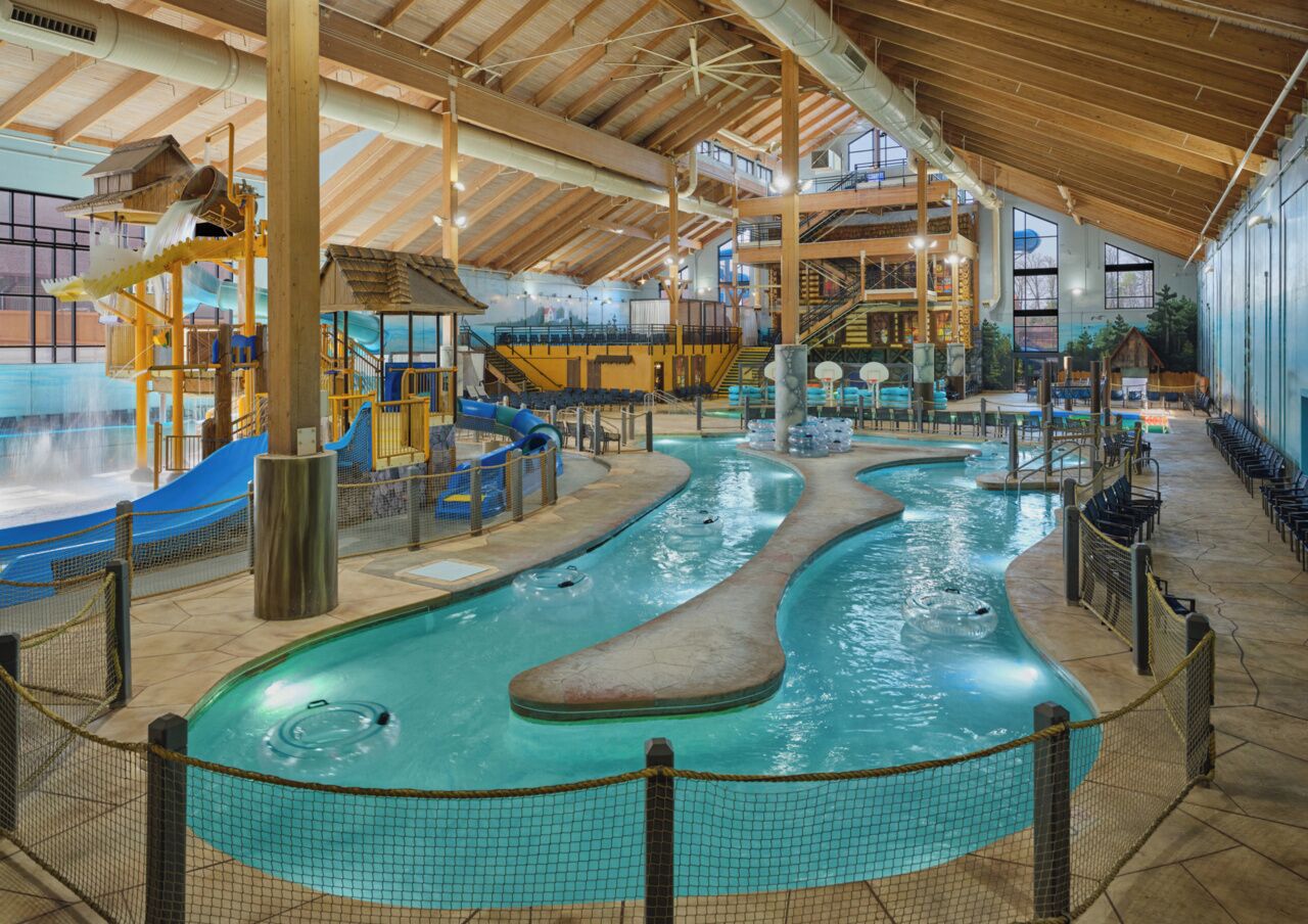An indoor swimming pool with a slide, a hot tub, and a play area.