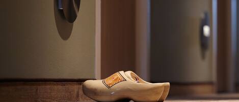 A pair of shoes on a wooden floor next to a door with the number 007.