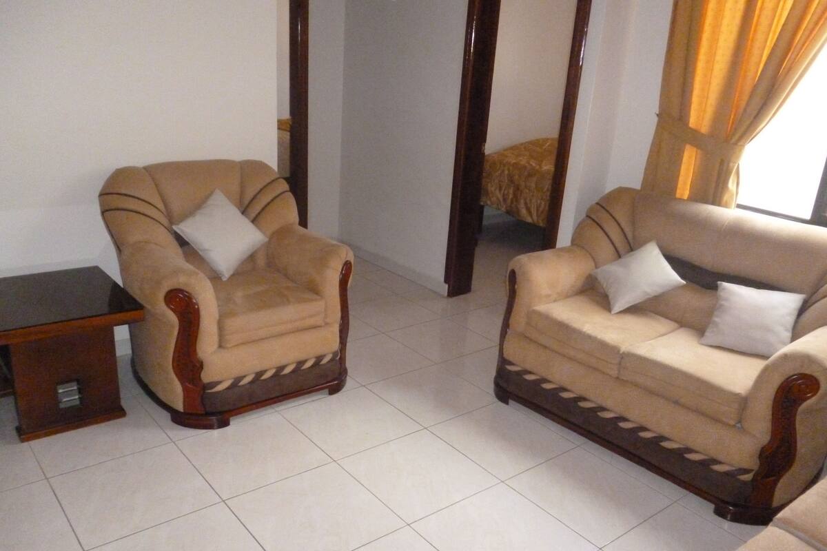 A living room with two armchairs and a small table.