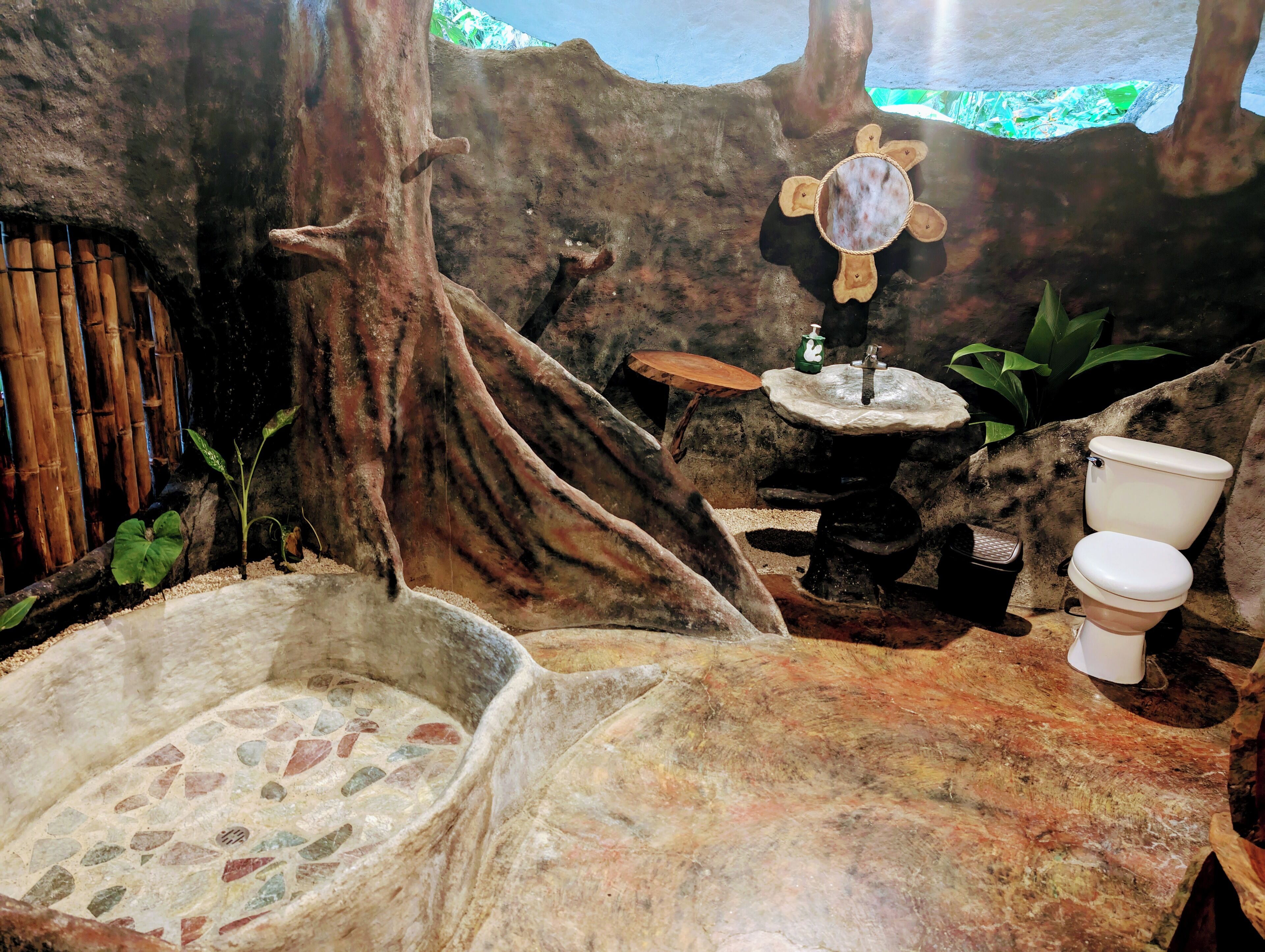 A bathroom with a stone sink, a toilet, and a small basin.