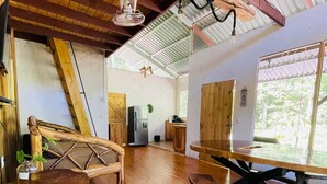 Un interior rústico con un banco de madera, una mesa y un ventilador de techo.