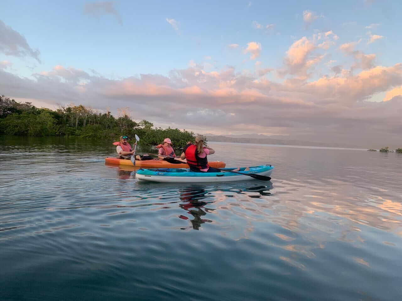 A calm lake with kayaks and canoes.