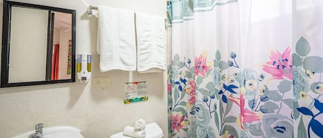 A bathroom with a sink, toilet, and a shower curtain with floral patterns.