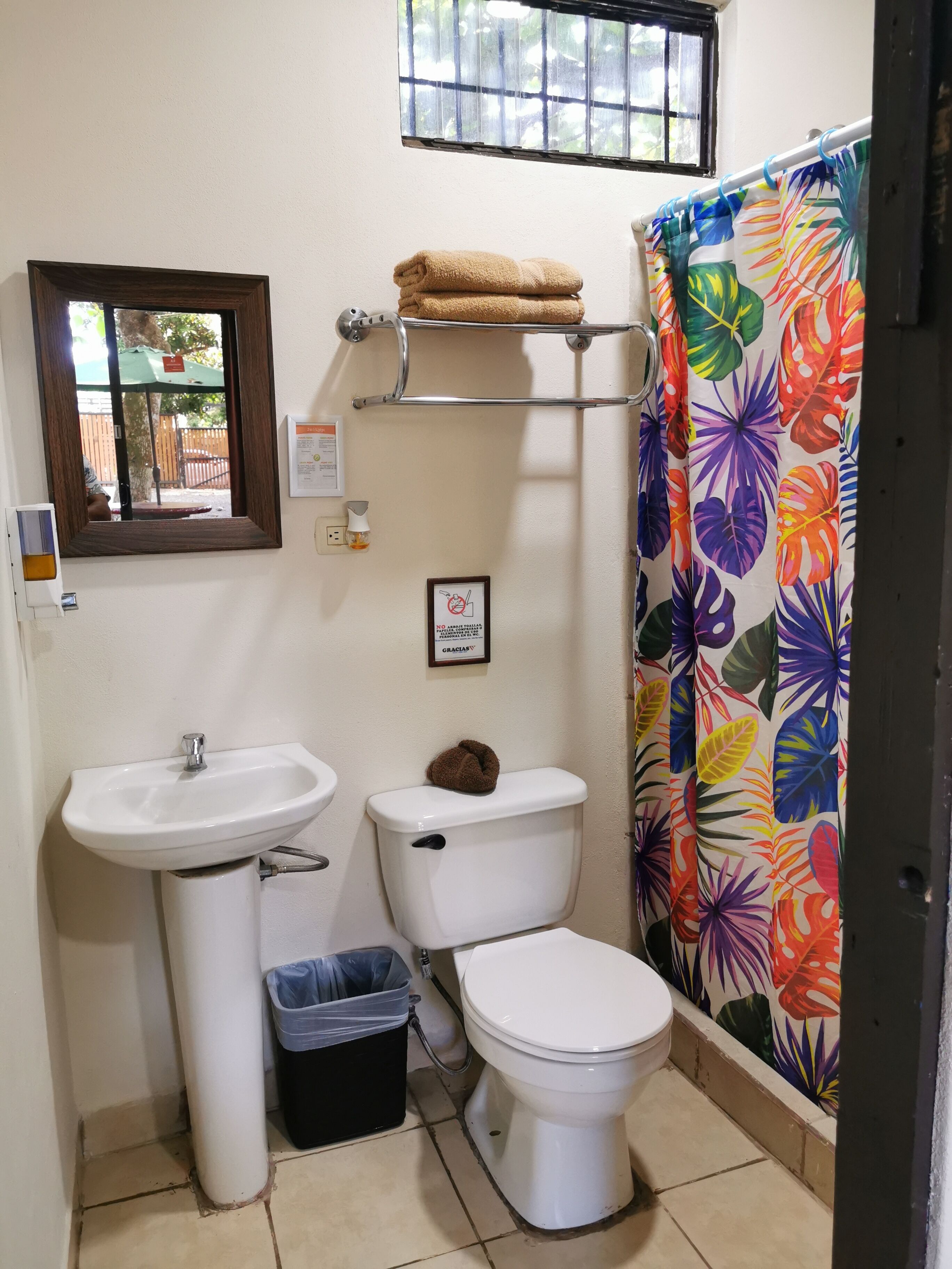 A small bathroom with a sink, toilet, and shower curtain.