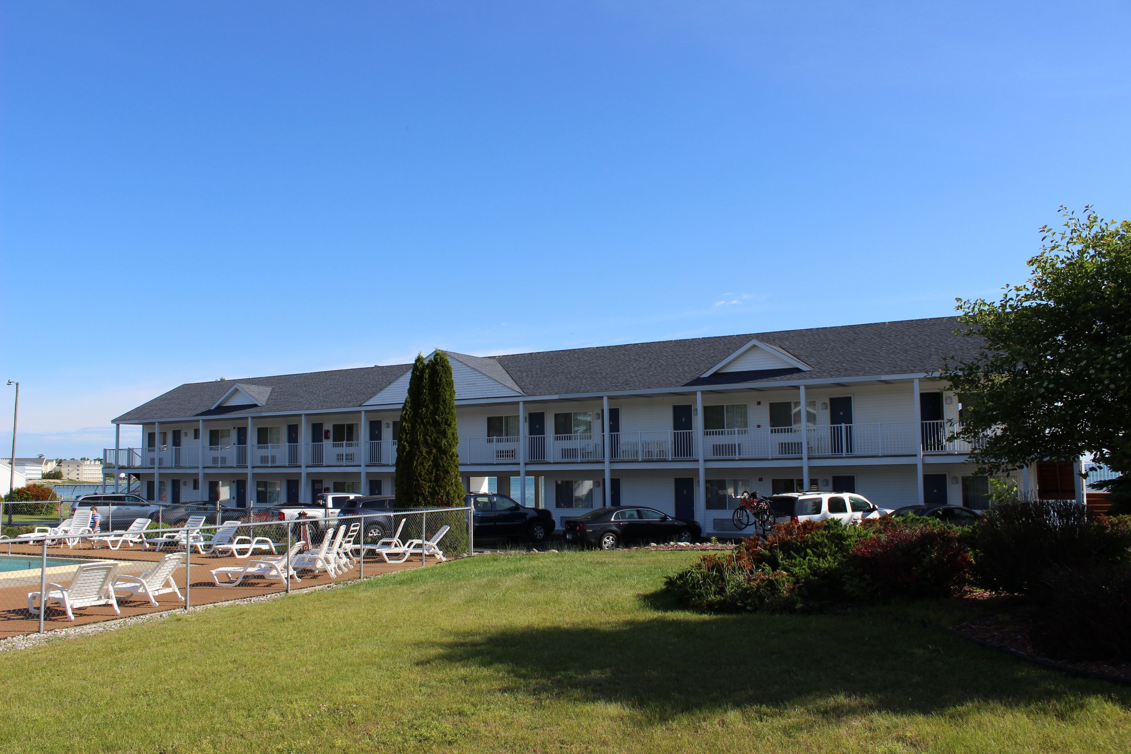 A motel with multiple floors, a swimming pool, and a parking area.
