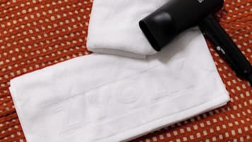 A white towel with the word "ZYLON" embossed on it, placed on a patterned orange and white surface.